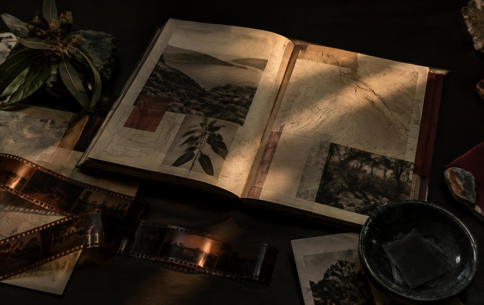 An open visual archive of landscape, maps and film on a dark table